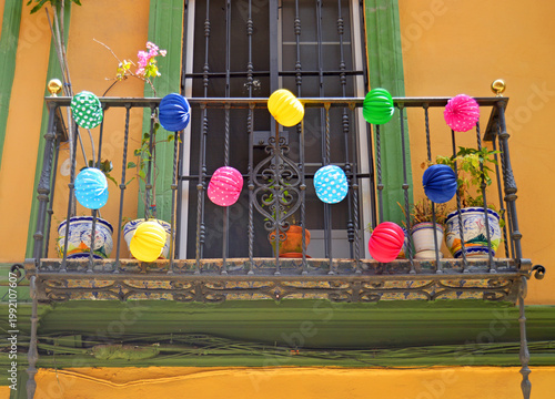 Balcon d'une maison typique de Séville, décoré de lanternes en papier multicolores pour la Feria de Abril (Feria de Sevilla). Ambiance joyeuse et colorée, véritable fête !