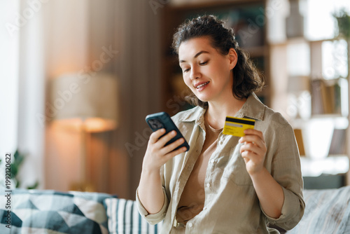 Happy Woman Shopping Online with Smartphone and Credit Card at H