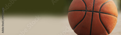 Close-up of a basketball on an outdoor court with soft bokeh background