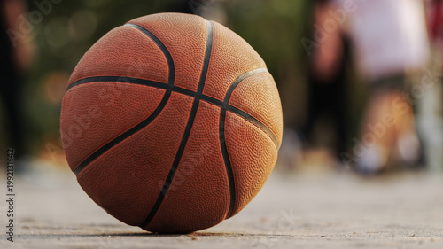 Close-up of a basketball on an outdoor court with soft bokeh background