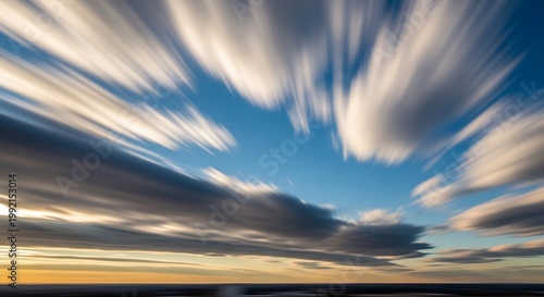 Dramatic motion blur landscape with sunburst over coastal mountains and golden sand dunes at sunset