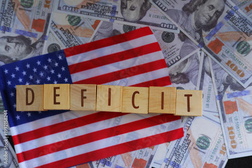 The US Budget Deficit is displayed using text and the US flag. The text DEFICIT is displayed with the US flag and US dollar in the background.
