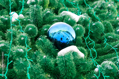 A blue shiny ball on a winter Christmas tree