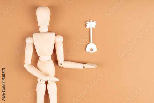 Wooden mannequin reaching toward key above, solution and opportunity concept