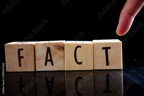 A conceptual image representing the significance of facts in our understanding of the world. The word 'FACT' spelled out in wooden blocks symbolizes the building blocks of knowledge and truth