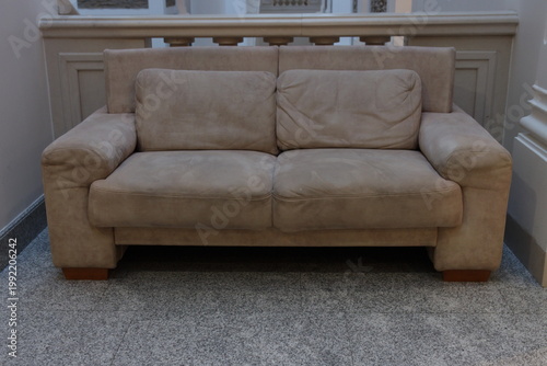 Beige sofa sits quietly in softly lit room