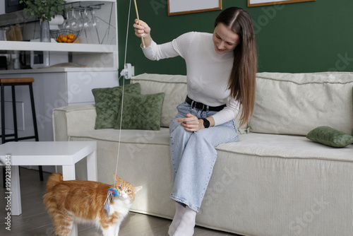 Attractive woman with cat playing and having fun at home