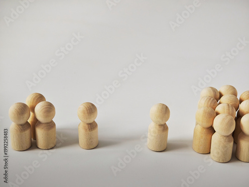 Wooden peg figures display leadership and teamwork concepts with focus on individuality and standing out in a neutral setting for business recruitment scenarios