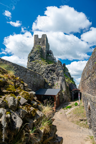 Close up view of the walls and iconic towers of Trosky Castle in Cesky Raj Czech Republic with massive stone structures rising above ruins in summer weather popular tourist destination