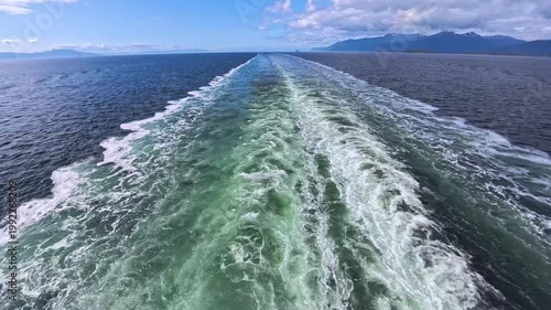 August 13, 2024 - Tracy Arm, Alaska - Scenic view of the boat wake as it travels through the calm waterway. The water and waves create a visually captivating sight with distant mountains.