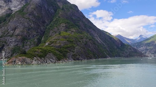 August 13, 2024 - Tracy Arm, USA - Scenic view of Tracy Arm Fjord in Alaska. The fjord surrounded by steep mountains, rocks and evergreen trees reflects in the calm water.