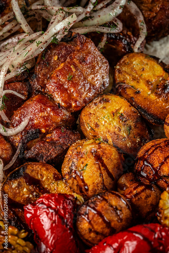 Close up grilled meat with roasted potatoes and vegetables