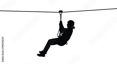 Silhouette of a person wearing a helmet while sliding quickly down a metal zip line rope cable
