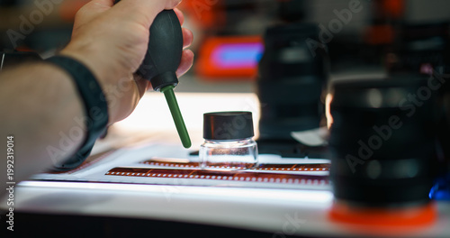 Photographer air blower cleaning film strips