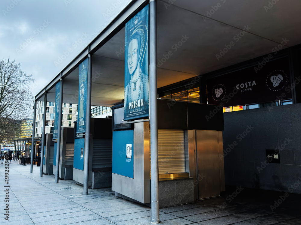 Naklejka premium Empty riverside kiosks and historical exhibition banners at riverside promenade in London UK with closed Costa Coffee and modern urban architecture