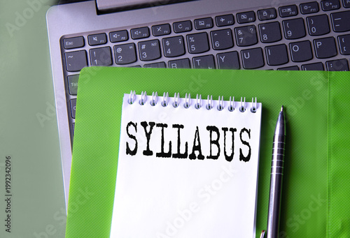 SYLLABUS - word in notebook on green folder and next to laptop