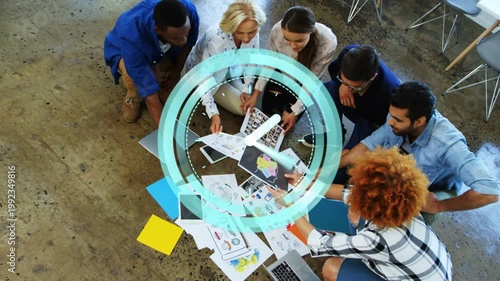 Six designers sorting prints reviewing layouts as teal overlay appearing over hands fading upward