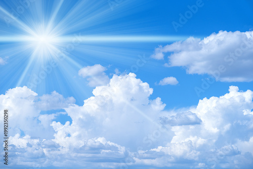 Bright blue sky with soft white clouds and glowing sun rays. Sunny natural background with copy space, perfect for advertising, banners, summer design, travel concepts and inspirational visuals