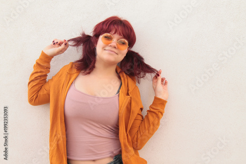Teenage girl with pigtails posing on a street wall