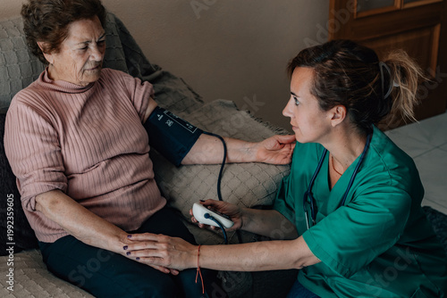 Bild auf Leinwand Home Healthcare -A healthcare professional measures an elderly woman's blood pre