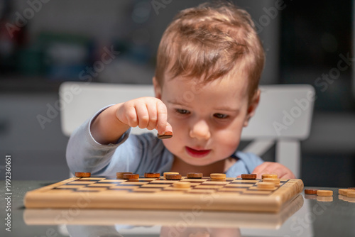 Adorable kid learning through checkers, combining fun and education. Selective focus.