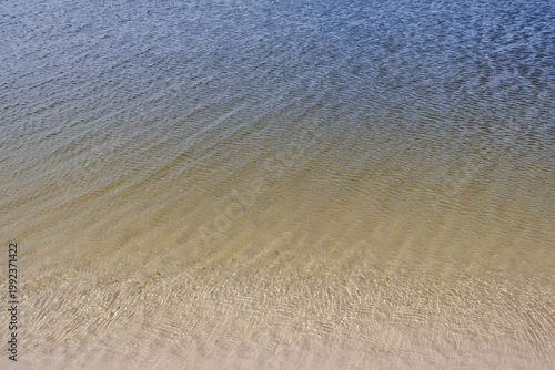 Ripples on shallow seawater with blue yellow colour gradient textured background