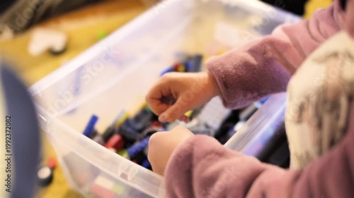 Children hands playing with colorful building blocks, creative toy construction, imagination and learning concept