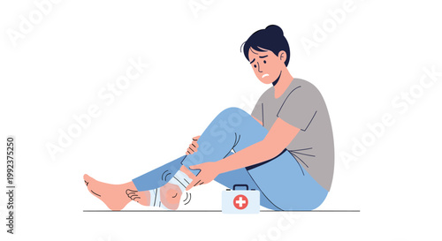 A woman sits on the floor with a pained expression while holding her bandaged and swollen red ankle next to a small white medical first aid kit.