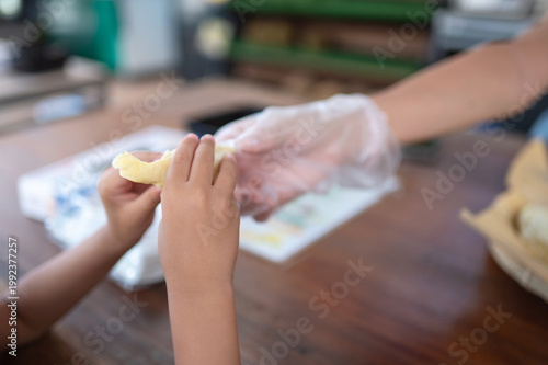 Child's Hands Receiving Durian in Local Market Setting