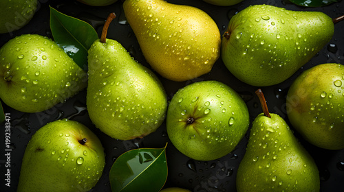 Top view of fresh green and yellow pears with water drops. Flat lay of wet organic fruit with leaves on dark background. Healthy raw vegetarian food