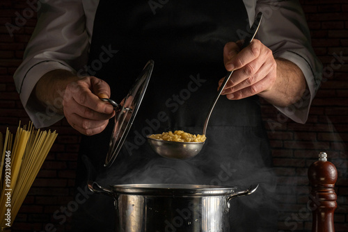 Fotografía A chef is focusing on cooking by ladling pasta from a pot