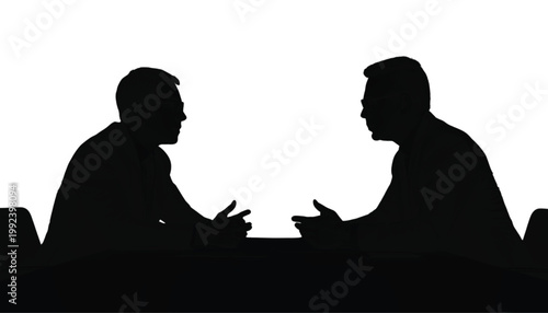 Businessmen sit across a table to engage in a formal professional discussion about current operations.