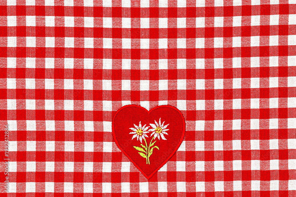 Obraz premium Checkered fabric with red and white pattern featuring a heart with flowers at the center
