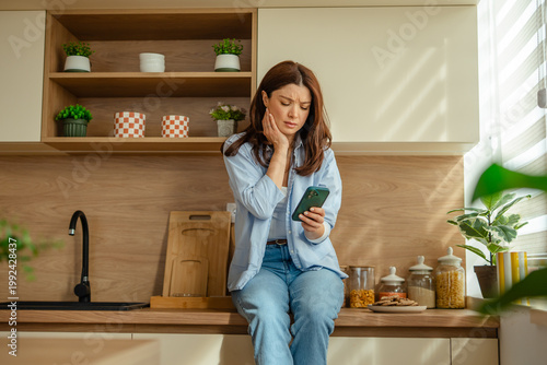 Cuadro en lienzo Woman experiencing toothache searching for dental care online