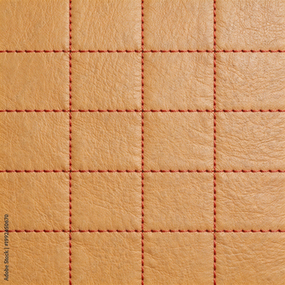 Fototapeta premium Quilted leather texture with red stitching