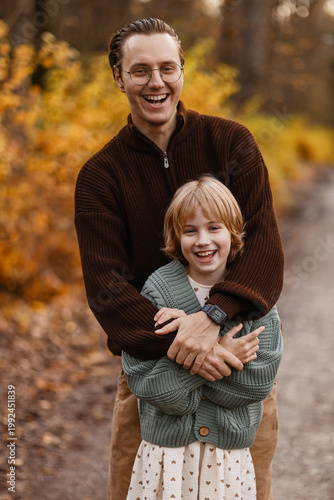 Father And Daughter Laughing Together Close Up On Forest Track, Joyful Expressions, Natural Light On Faces And Layered Autumn Tones Creating Upbeat Family Lifestyle Portrait Filled