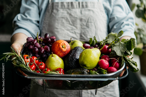 Hands holding big tray with different fresh fruits and vegetables. Harvest and healthy organic food concept.
