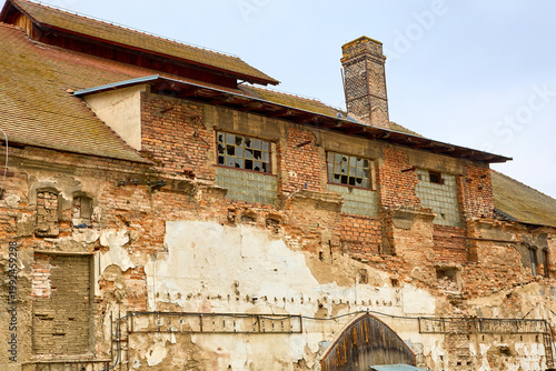 Weathered brick building with broken windows and worn plaster