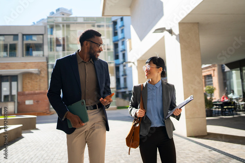 Two professionals walking and talking outside