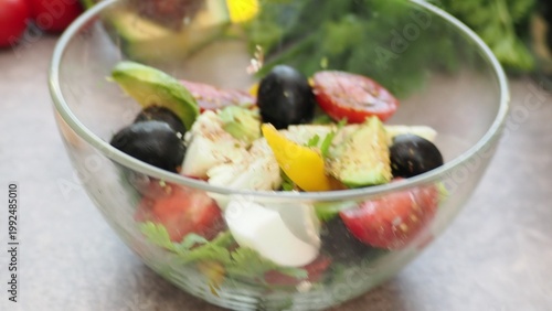 A girl prepares a delicious, low-calorie, and healthy salad. Keto diet. Balanced protein and fat, high in fiber. Salad with avocado, greens, bell pepper, egg, olives, parsley, and dill, tomatoes