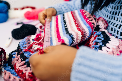 Close up of hands measuring a crotchet piece