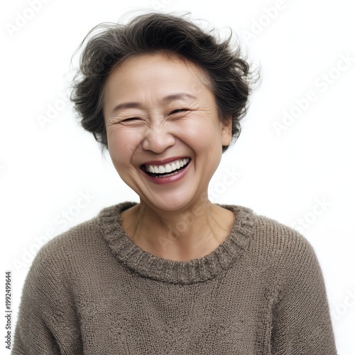 Cheerful woman laughing, wearing a cozy sweater, against a white background, showcasing happiness and joy.