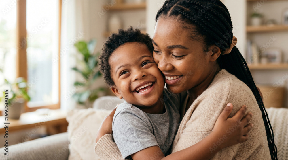 Obraz premium Happy Black mother and her young son with Down syndrome sharing a warm embrace indoors, inclusive parenting and bonding.