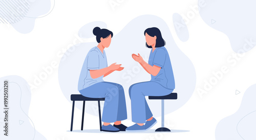 Two nurses in blue uniforms talking and gesturing while sitting on stools