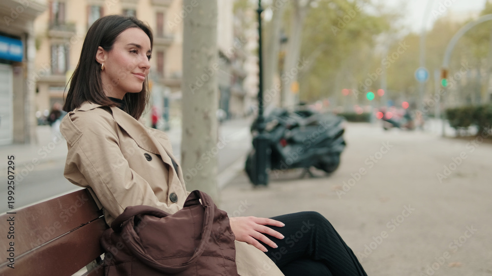 Obraz premium Woman Sitting On A Bench In City Street