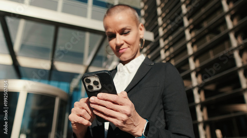 Professional Woman Using Smartphone Outside Modern Building