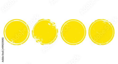 four distressed yellow circular stamps with grunge texture isolated on a white background perfect for abstract graphic design elements.