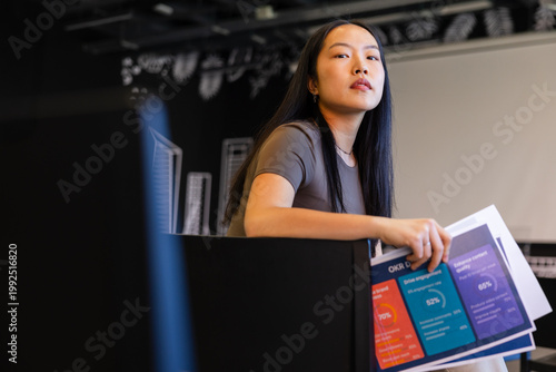 Professional woman holding business documents in office