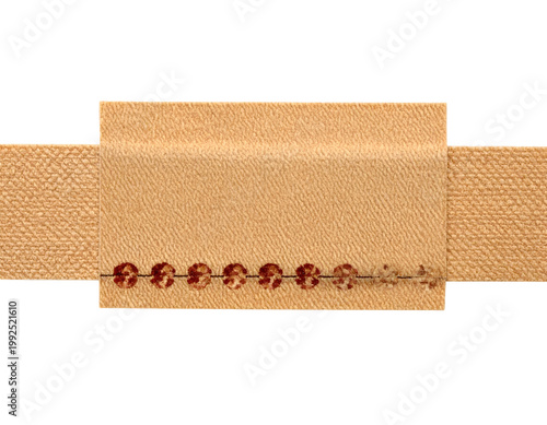Beige fabric tag with embroidered sequins on a textured ribbon
