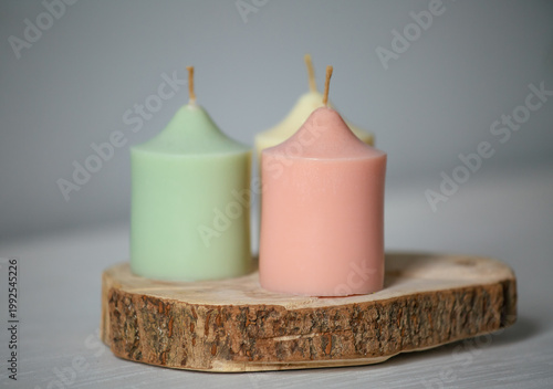 Three colorful magic calm not burning design candles in home interior on wooden candlestick. Closeup yoga, spa, wellness, relaxation concept